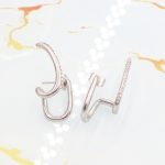 Ατσάλινα σκουλαρίκια Diplo σε ασημί χρώμα, διακοσμημένα με λευκά στρας.