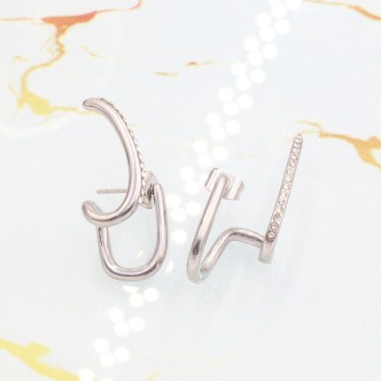 Ατσάλινα σκουλαρίκια Diplo σε ασημί χρώμα, διακοσμημένα με λευκά στρας.