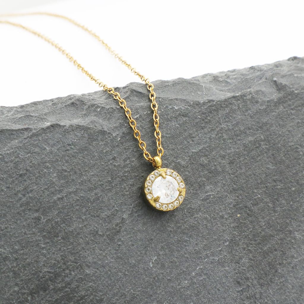 Κοντό ατσάλινο κολιέ με στρογγυλό κρύσταλλο, σε χρυσό χρώμα Κοντό ατσάλινο κολιέ με στρογγυλό κρύσταλλο, σε χρυσό χρώμα