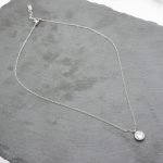 Κοντό ατσάλινο κολιέ με στρογγυλό κρύσταλλο, σε ασημί χρώμα