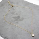 Κοντό ατσάλινο κολιέ με στρογγυλό κρύσταλλο, σε χρυσό χρώμα