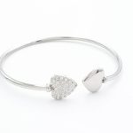 Ατσάλινο βραχιόλι τύπου χειροπέδα σε χρυσό χρώμα, με 2 καρδιές, η μία διακοσμημένη με μικρά στρασάκια. Είναι ανοιχτή και προσαρμόζεται εύκολα.